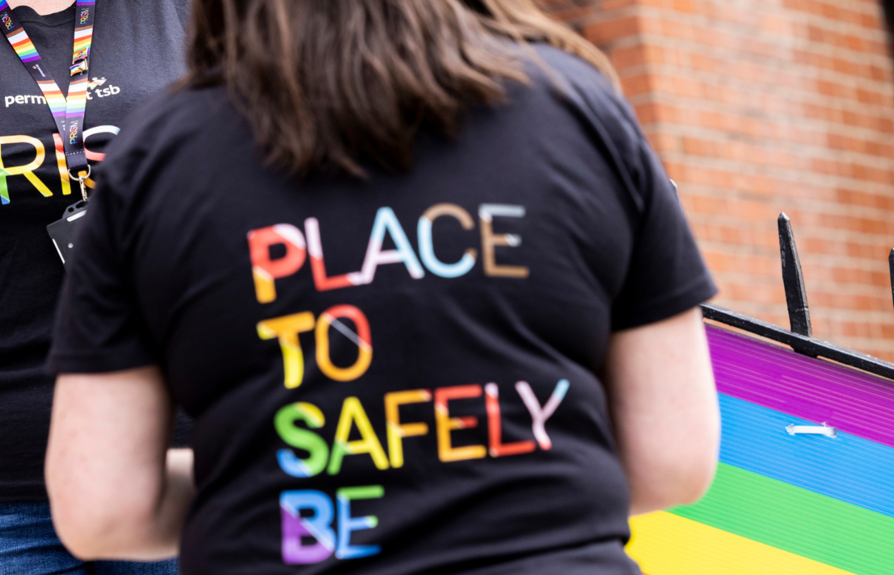 Woman wearing black T-shirt with text 'Place to Safely Be'
